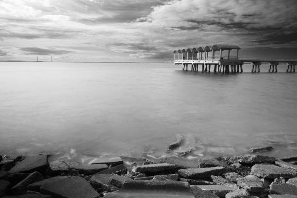The Jekyll Island Pier and the Sidney Lanier Bridge with winter clouds above.