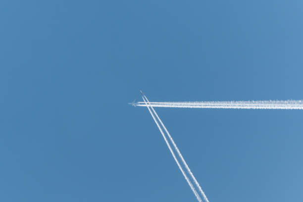 istock Two airplanes flying in the sky with their exhaust trailing behind them 2201754846