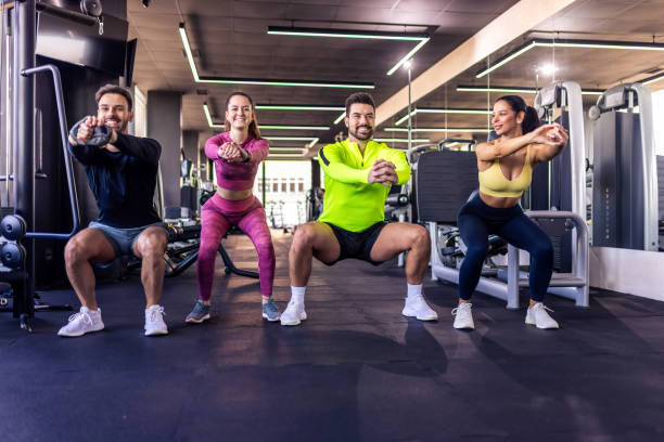 istock Group of people doing squats together in the gym. 2201755294
