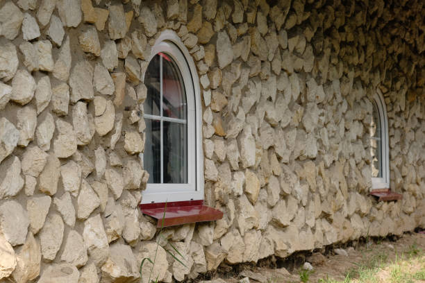 The stone wall with two arched windows in the antique style.