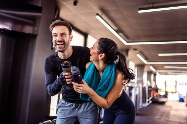 istock Two gym partners laugh in the gym with their water bottles. 2201757572