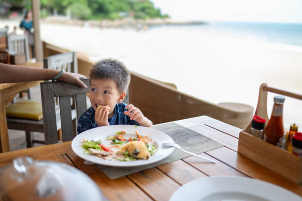istock Young Child Enjoying a Tasty Meal at the Beach 2201757650