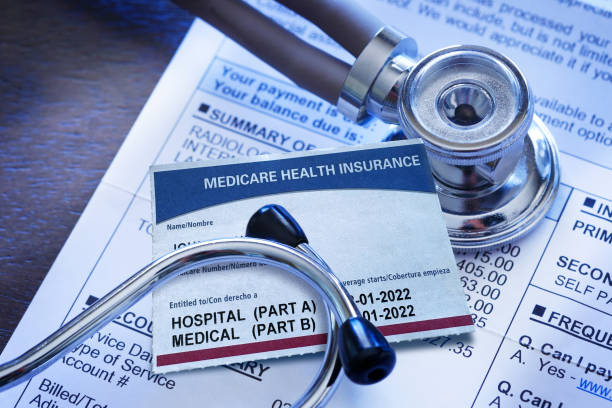 tarjeta de seguro de medicare y estetoscopio en una factura médica - medicare fotografías e imágenes de stock