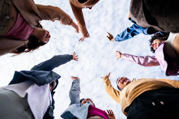 Friends with hands raised outdoors