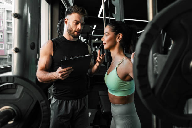 istock Young Woman Preparing for a Heavy Deadlift Workout With Personal Trainer 2201760808