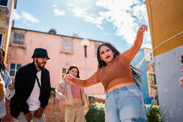 istock Young woman dancing with friends outdoors 2201760875