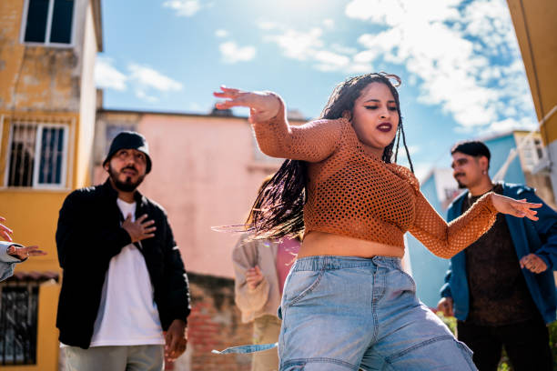 istock Young woman dancing with friends outdoors 2201760877