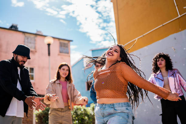 istock Young woman dancing with friends outdoors 2201760882