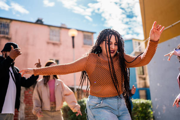 istock Young woman dancing with friends outdoors 2201760883