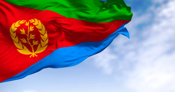 Eritrea national flag waving on a clear day. Red triangle on hoist, green and blue triangles, gold emblem of olive branch & wreath. 3d illustration render. Fluttering fabric