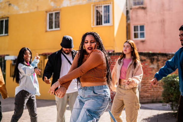 istock Young woman dancing with friends outdoors 2201760936