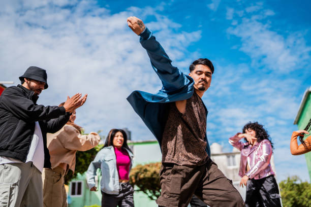 istock Young man dancing with friends outdoors 2201761076