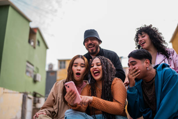 istock Young friends using mobile phone and talking outdoors 2201761840