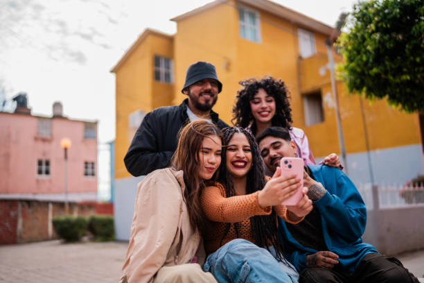 istock Young friends using mobile phone and talking outdoors 2201761930