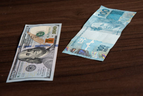 istock dollar and Brazilian real banknotes financial value money 2201764313