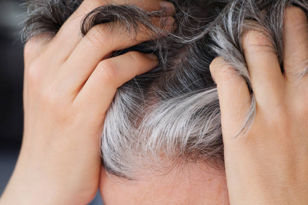 istock A woman showing her gray hair. Going gray concept. 2201765879