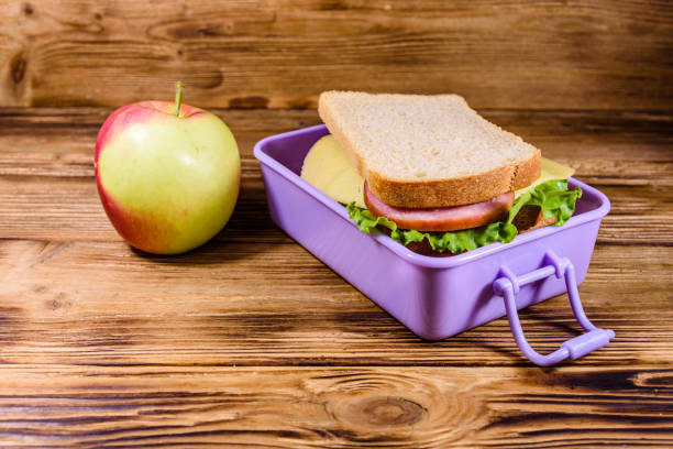 The gray background in the picture is a food container for taking out of the house. There are green, blue, and red three-layer containers with yellow handles. They are made of thick plastic