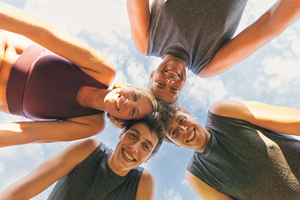 istock Smiling family in sportswear huddled together outdoors from below 2201770472