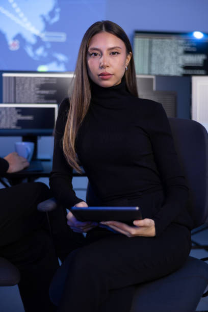 istock Serious Female Cybersecurity Analyst in large Cyber Security Operation Center SOC handling Threats 2201772137