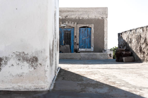 Old houses in a peaceful village on a greek island. Classic colours of Greece, white and blue in a washed out scenery. Nostalgic atmosphere.