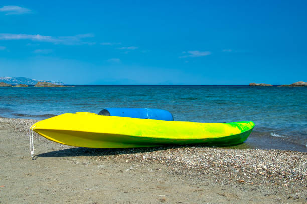 Close up of a kayayk on the beach with rough water of a bay in the background on a beach on Long Island.