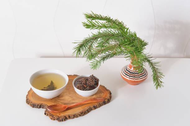 Herbal tea with pine cone jam on wooden board