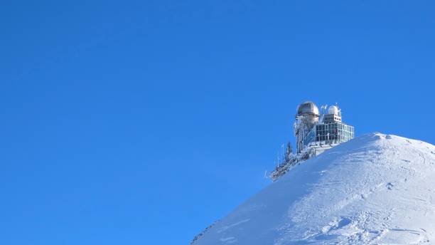 istock The snow-covered peak of Jungfrau with the Sphinx Observatory perched on top. The structure has domes and glass panels, standing against a clear blue sky at the 'Top of Europe'. 2201775868