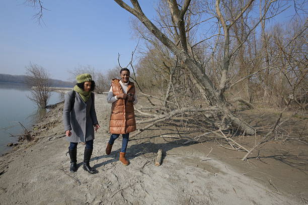 istock Two young women walking by the river in winter 2201784439