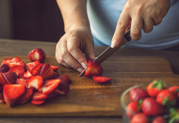 istock Woman Cutting Fresh Strawberries 2201788186