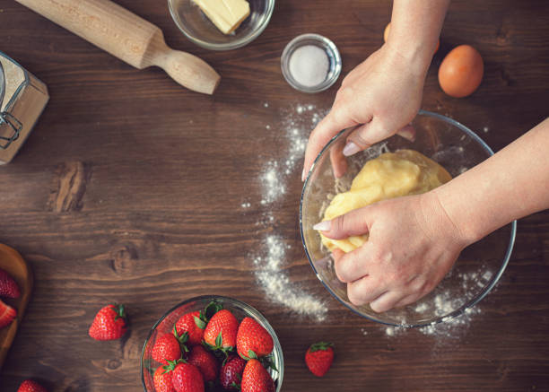 Woman preparing strawberry galette or open strawberry pie