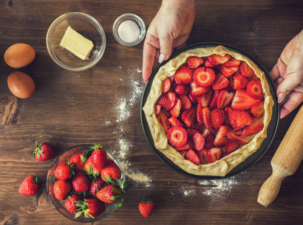 istock Woman preparing strawberry galette or open strawberry pie 2201788225