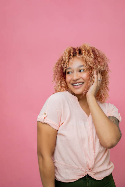 istock Beautiful Black woman smiles while touching her cheek in portrait 2201793414