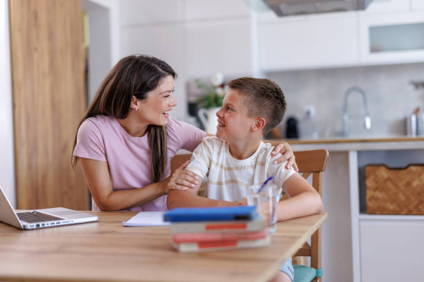 istock Mother helping her son with homework at home 2201793510