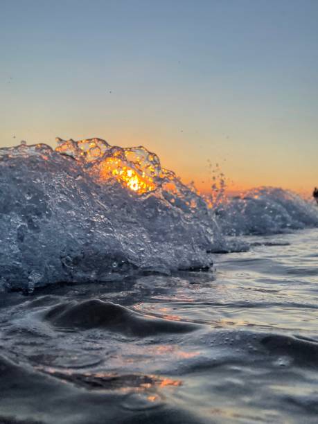 istock Golden sunset reflecting through ocean waves, capturing water in motion with warm and cool contrasts 2201793559