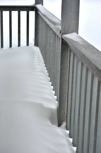 istock snow drift through a wooden porch railing 2201794039
