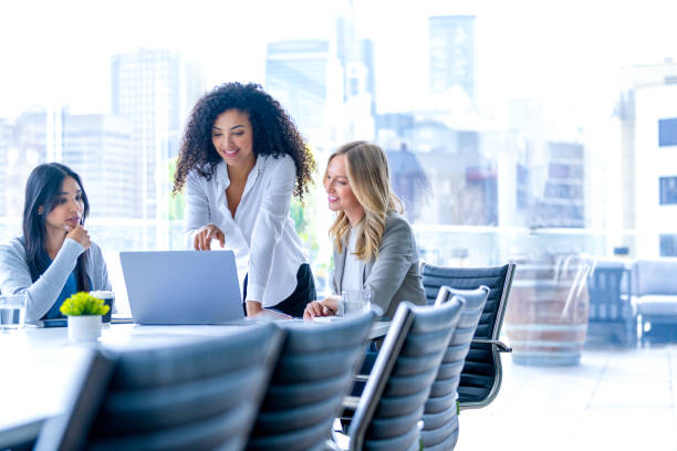 istock Three business  women meeting. They are discussing something while looking at a laptop computer. 2201794185