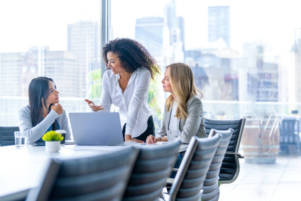 Three business  women meeting. They are discussing something while looking at a laptop computer.