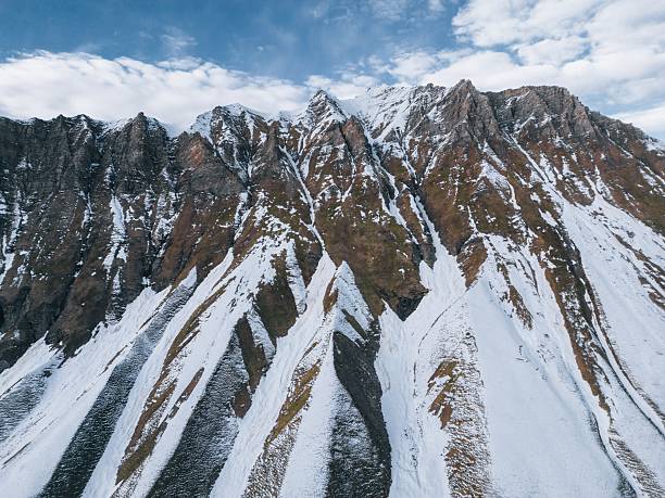 istock high relief mountains covered with snow, mountain range, aerial view drone shot 2201795167