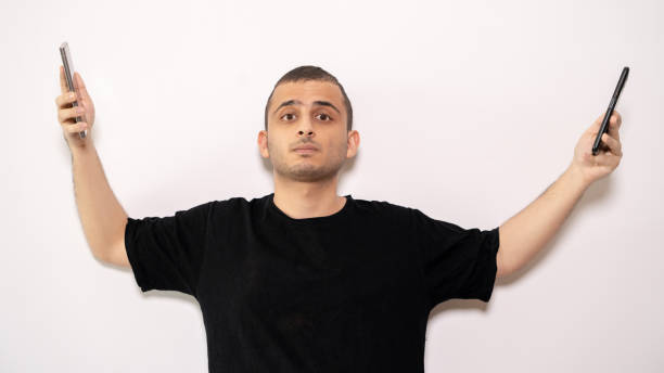 istock Man Holding Two Smartphones with Open Arms 2201795182