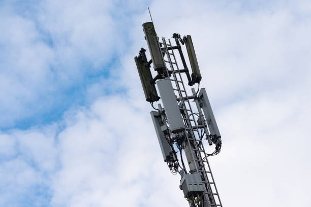 istock Cell tower stands tall against a cloudy sky in urban setting 2201796095