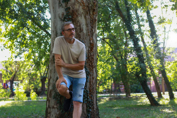 istock Casual relaxing silver senior man in public park 2201796926