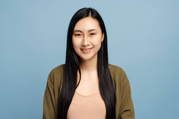 istock Young asian woman smiling on blue background 2201797509
