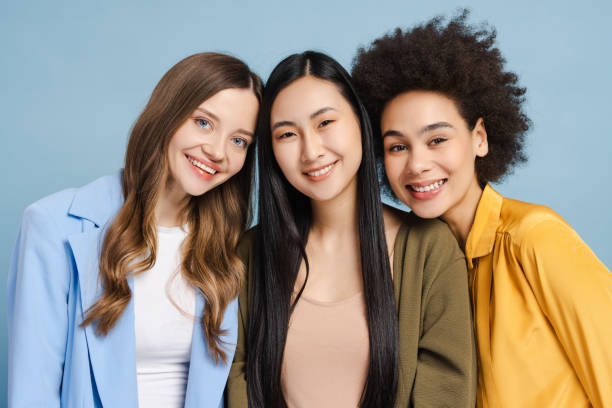 istock Three smiling businesswomen embracing diversity and teamwork on blue background 2201797525