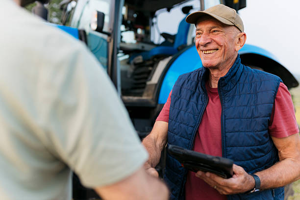 istock Smiling elderly farmer meeting a man on the farm 2201798422