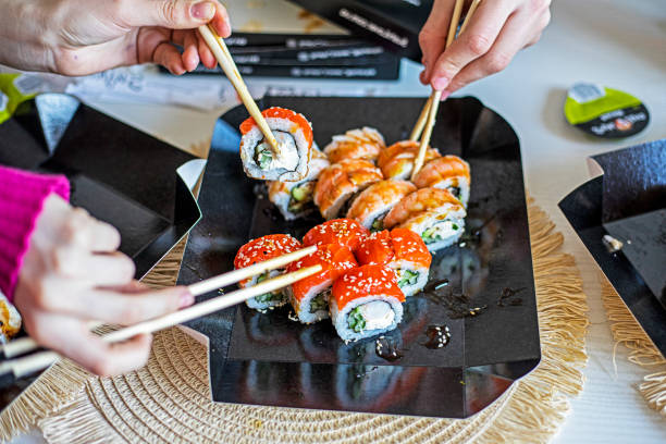 istock family eats sushi rolls set with chopsticks. festive evening in japanese style 2201798867