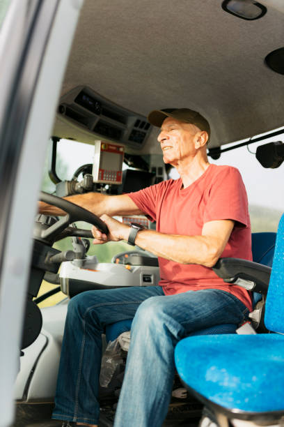 istock Side view of senior farmer operating a tractor on his farmland 2201799084