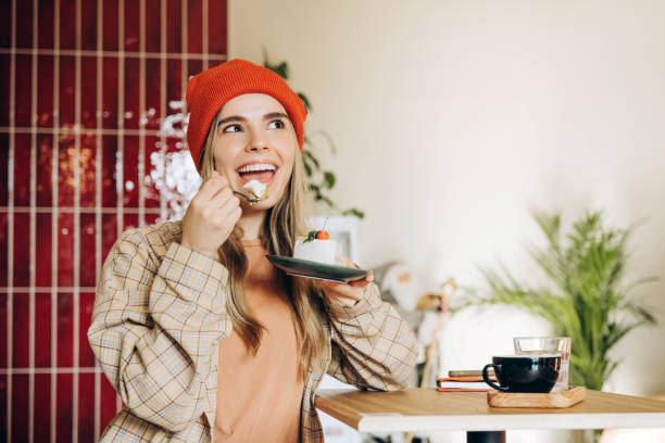 istock Happy woman eating cake and drinking coffee in cafe 2201800044
