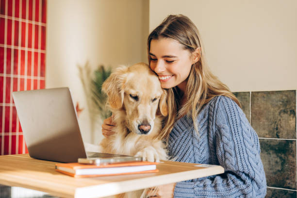 istock Woman working from home with golden retriever using laptop 2201800093