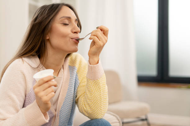 istock Woman enjoying a yogurt snack at home 2201801682