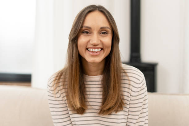 istock Young latin woman smiling and relaxing on sofa at home 2201801738
